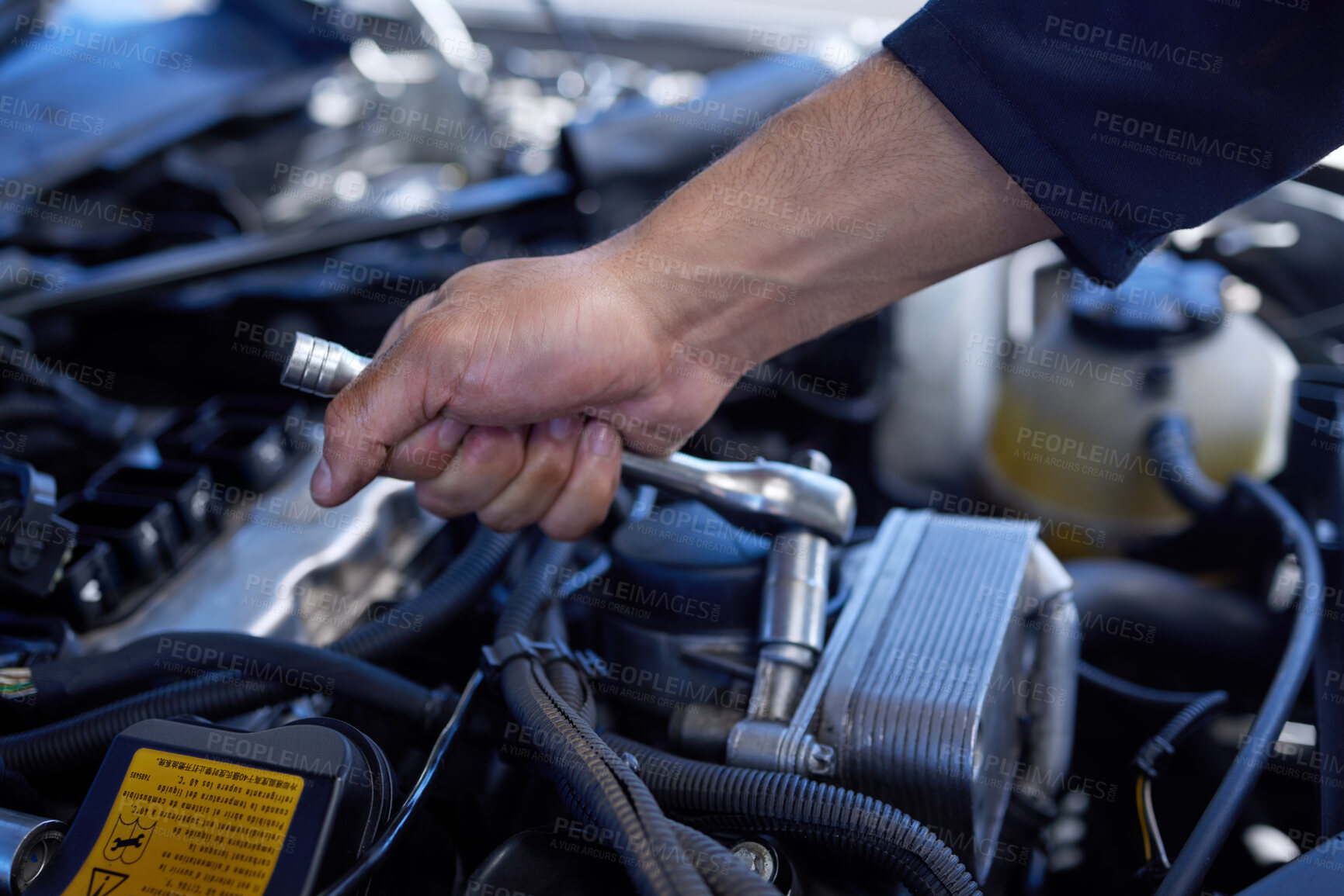 Buy stock photo High angle shot of an unrecognizable male mechanic working on the engine of a car during a service