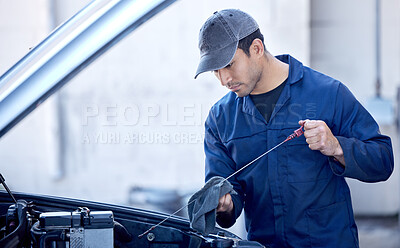 Buy stock photo Cropped shot of a handsome young male mechanic working on the engine of a car during a service