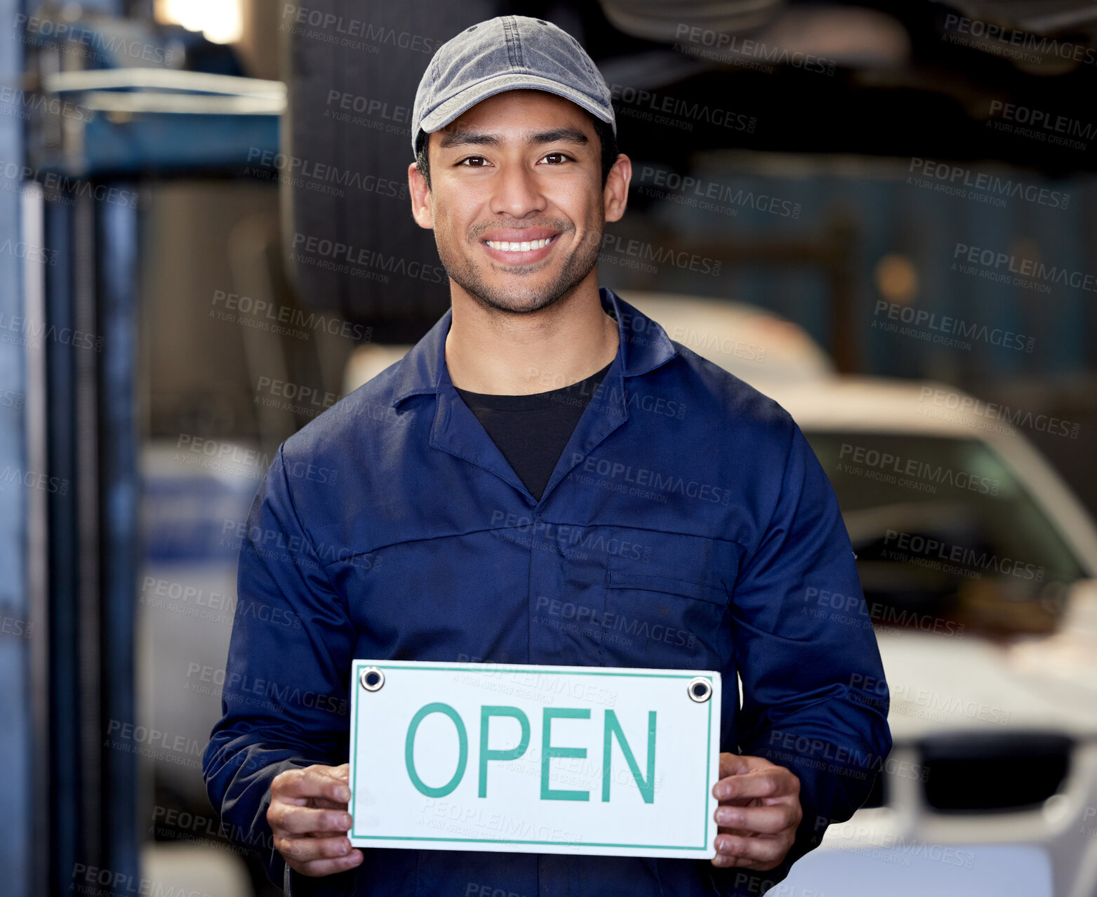 Buy stock photo Happy, man and mechanic with open sign in car workshop for welcome, vehicle repairs and expert advice. Smile, male person and engineer with poster for invitation to garage for automobile maintenance