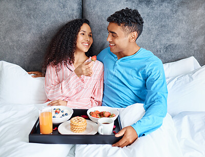 Buy stock photo Happy, couple and breakfast in bedroom for love, care and eating or sharing on weekend morning. People, man and woman together in home with smile and food for health, nutrients and relationship