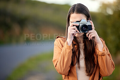 Buy stock photo Shot of a young woman using her camera while spending time outdoors