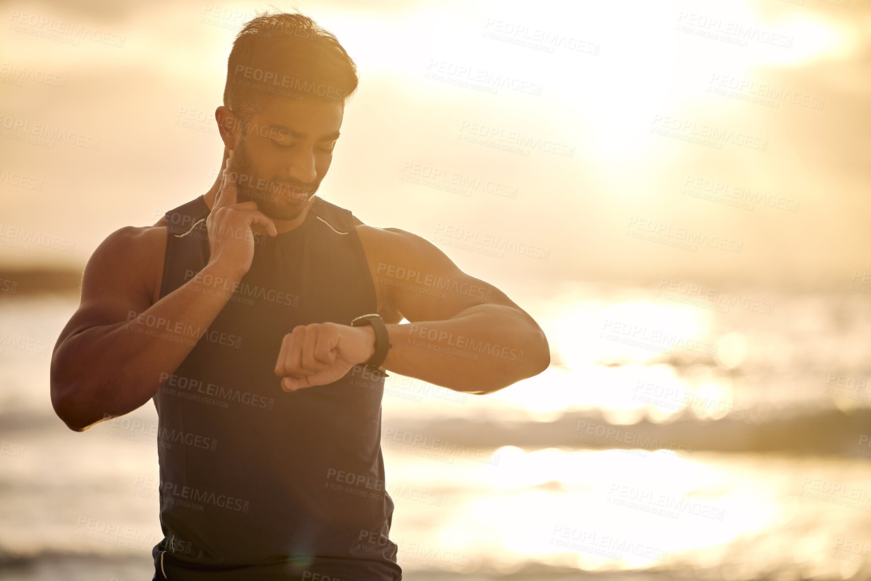 Buy stock photo Sunset, beach and man with smart watch for heart rate tracker, fitness and workout in nature. Exercise, ocean and runner mobile app checking pulse or time on stopwatch in silhouette with mockup space