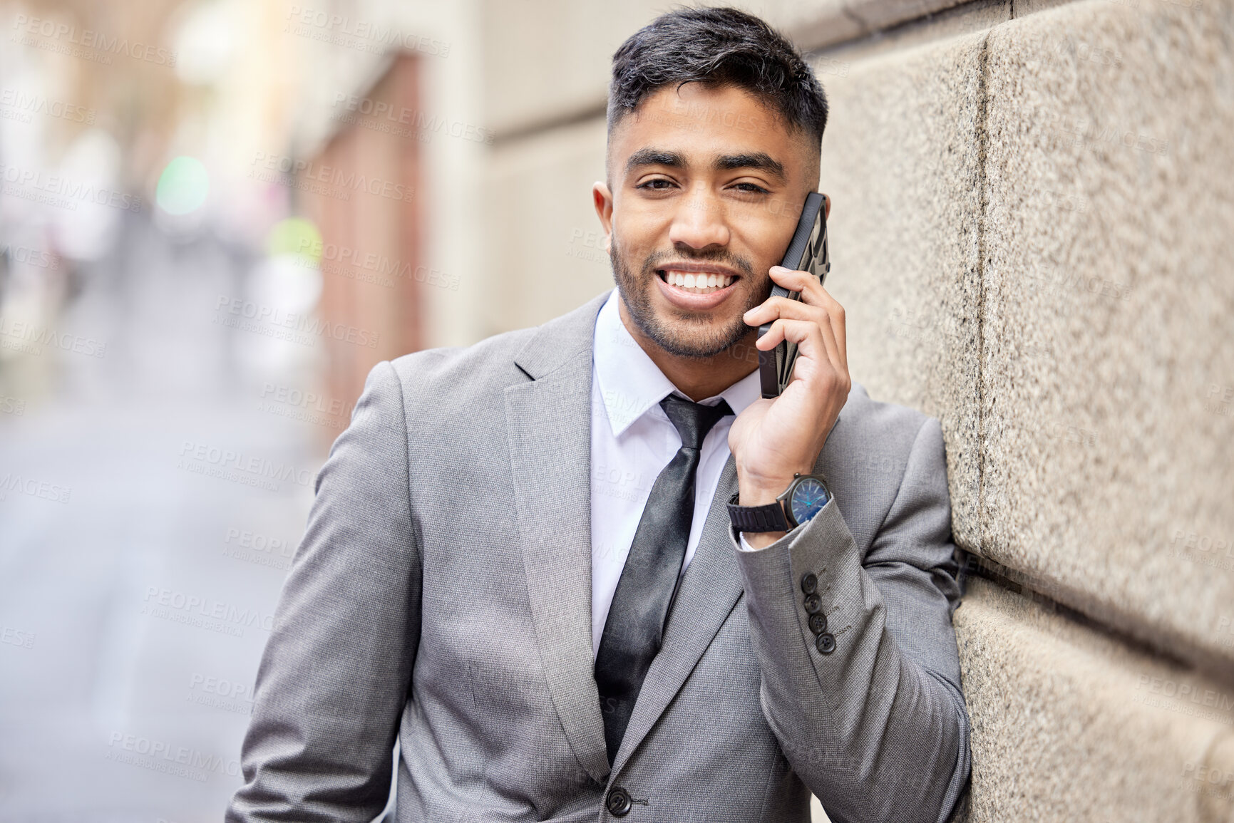 Buy stock photo Phone call, portrait and happy businessman in city on wall for talking, conversation and agent listening to contact. Mobile, face and smile of Indian professional in discussion outdoor for networking