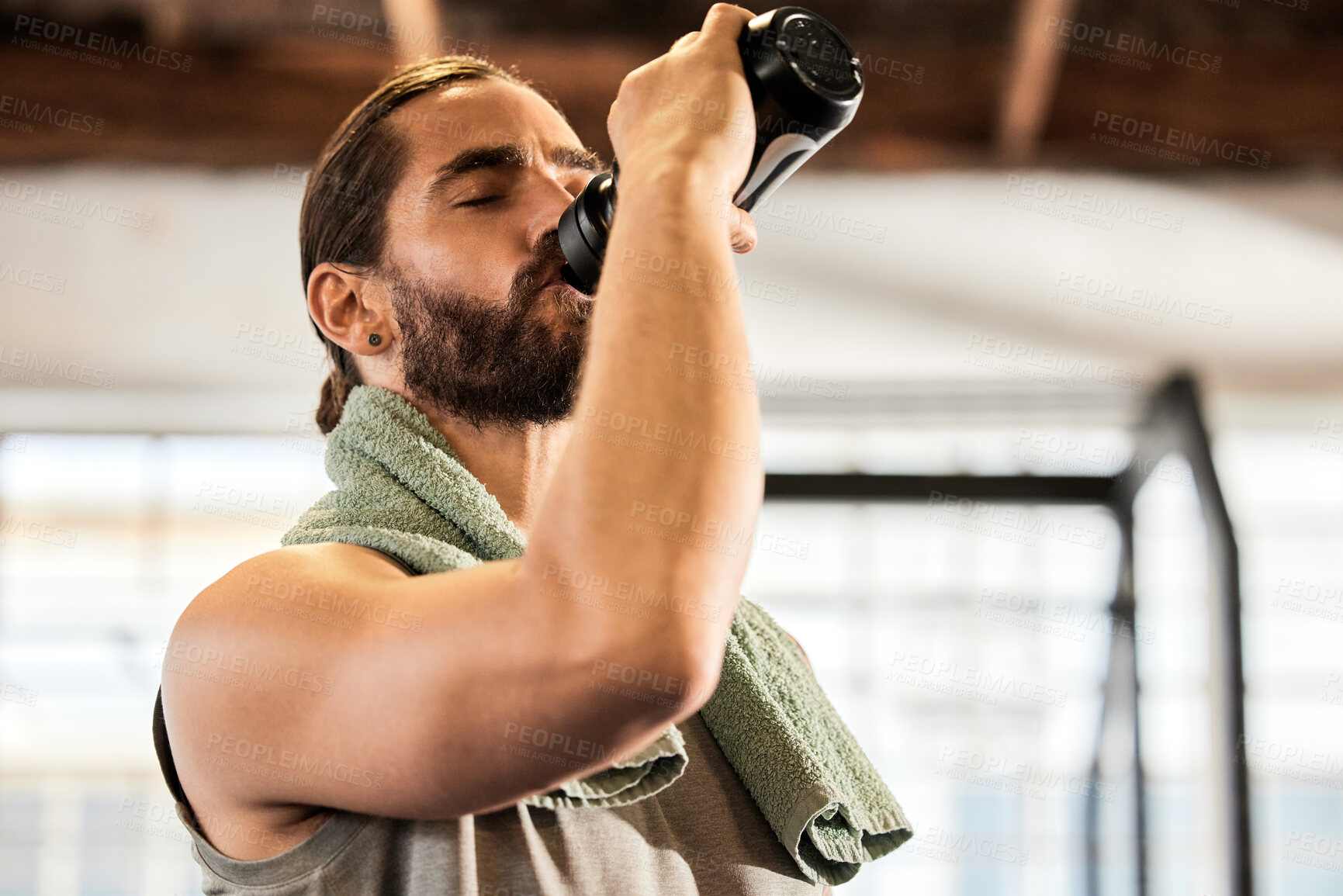 Buy stock photo Tired, break and a man drinking water in the gym after training, hydrating and thirsty after a workout. Fitness, health and a hydrated person with a bottle to drink after sports, cardio or exercise