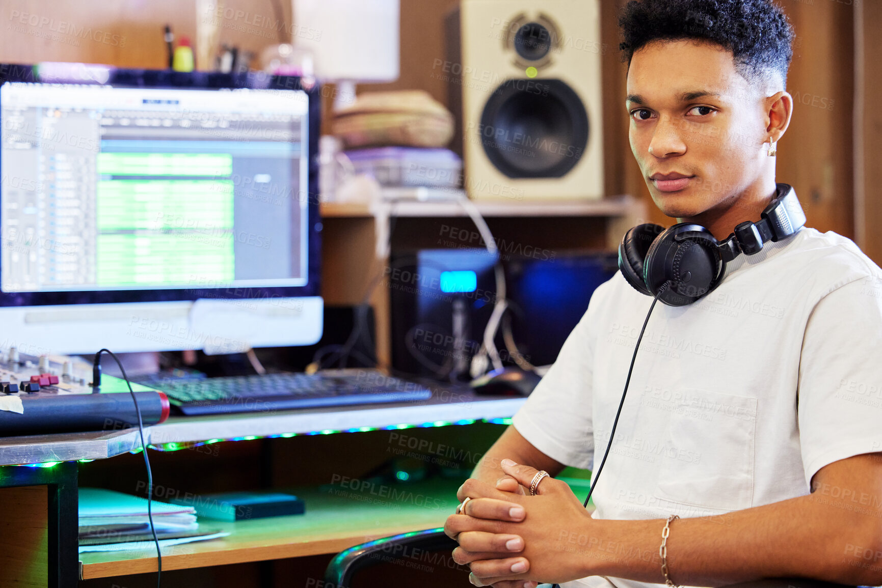 Buy stock photo Cropped portrait of a handsome young male music producer working in his home office