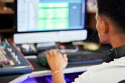 Buy stock photo Rearview shot of an unrecognizable male music producer working on his mix in the office