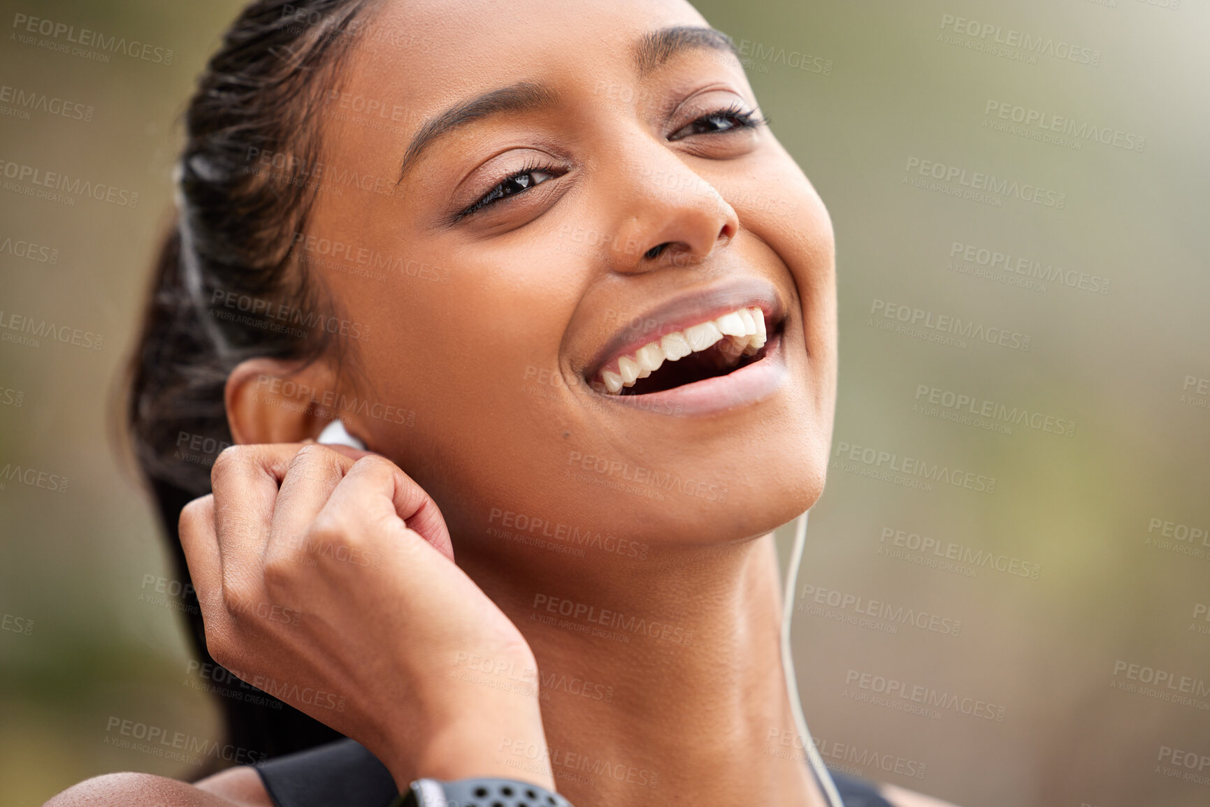 Buy stock photo Shot of a young woman listening to music while jogging