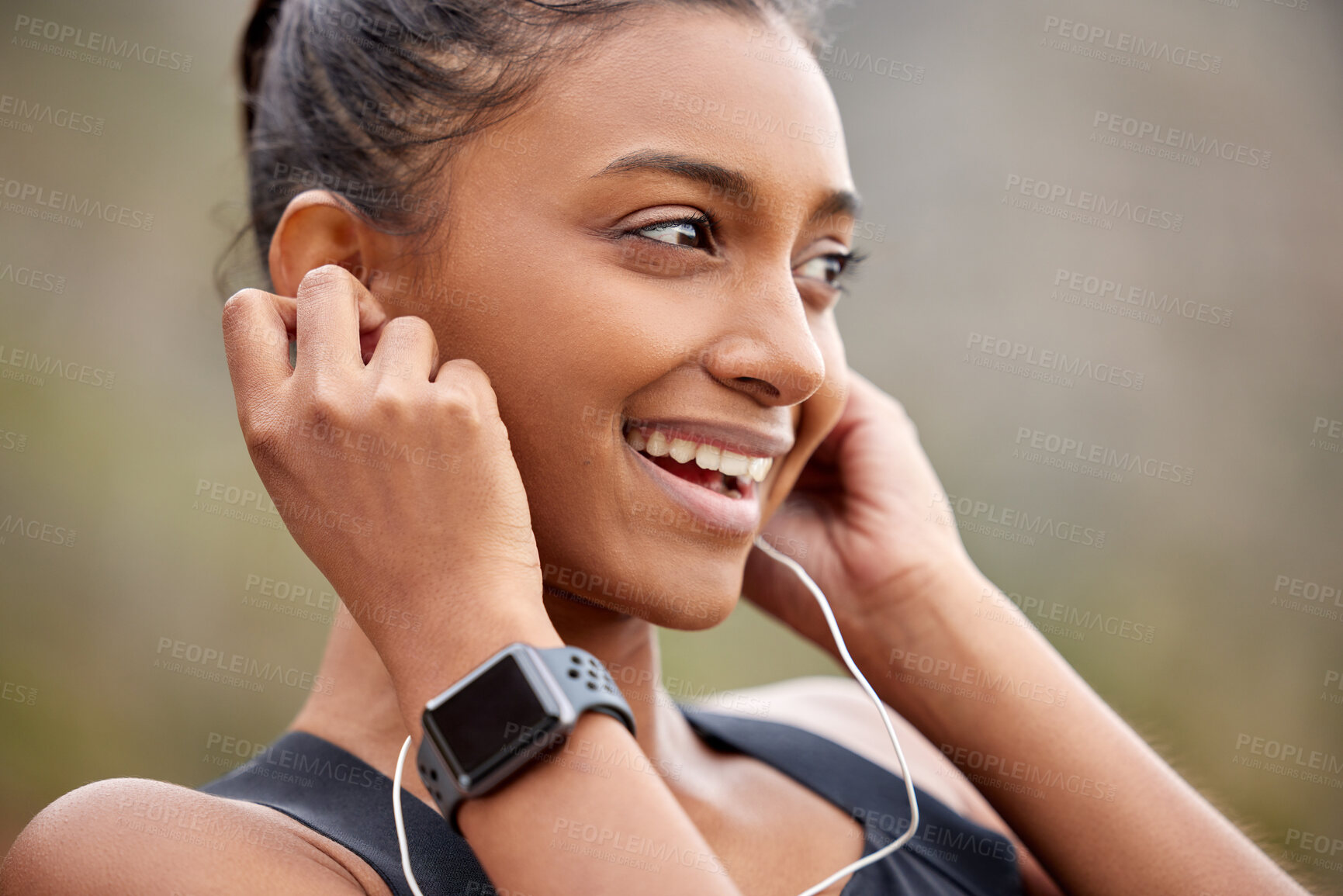 Buy stock photo Shot of a young woman listening to music while jogging