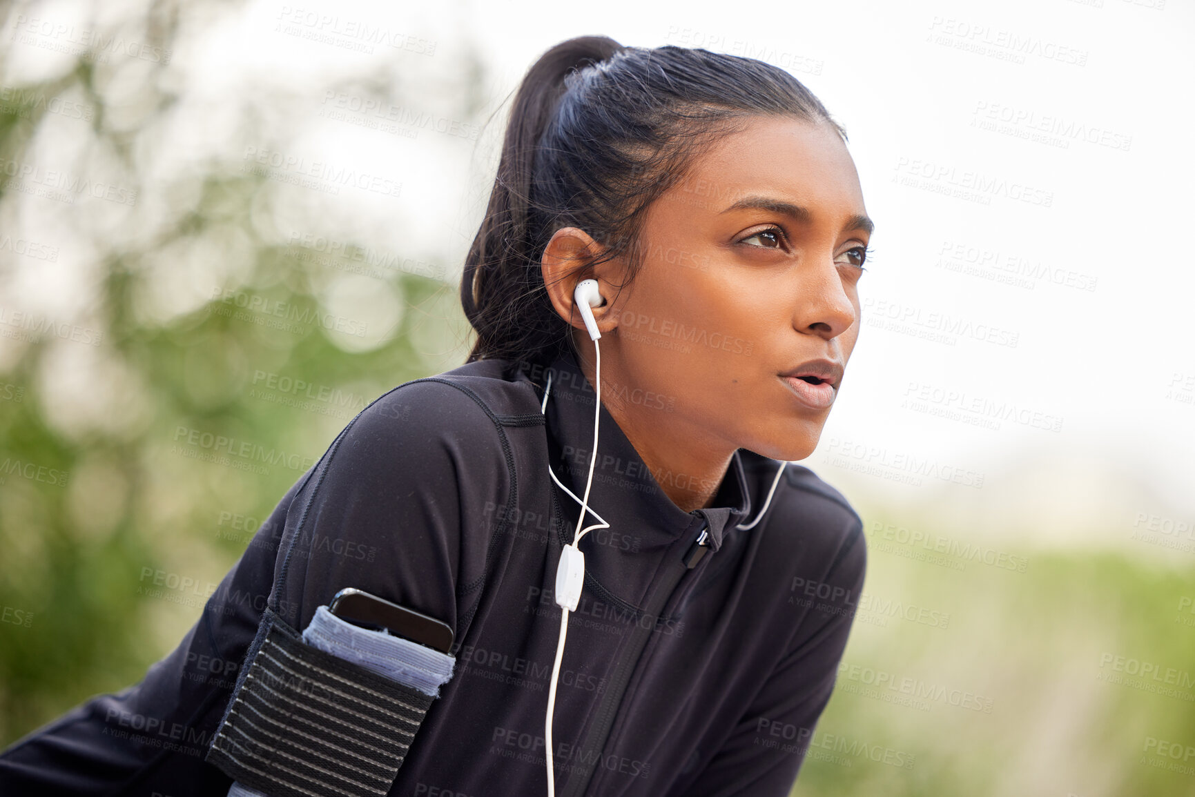 Buy stock photo Shot of a fit young woman catching her breathe while completing her jog outdoors