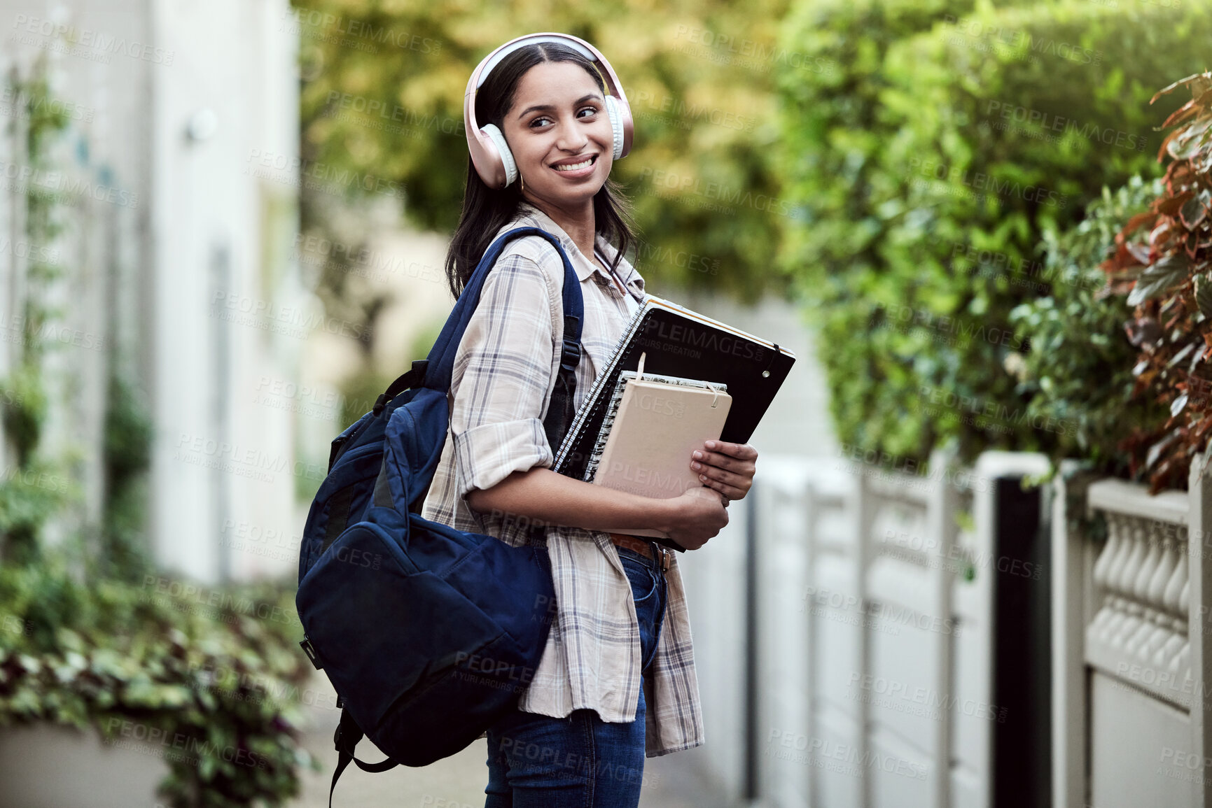 Buy stock photo Student, girl and backpack on campus with smile, headphones and books for learning, development and study. Female person, happy and university for class, course or degree as gen z for education