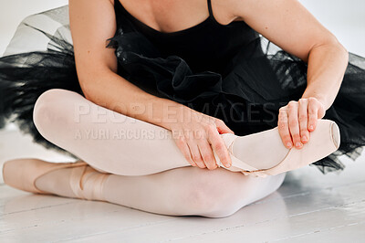 Buy stock photo Cropped shot of an unrecognizable female ballerina rubbing her feet in pain while sitting in the dance studio