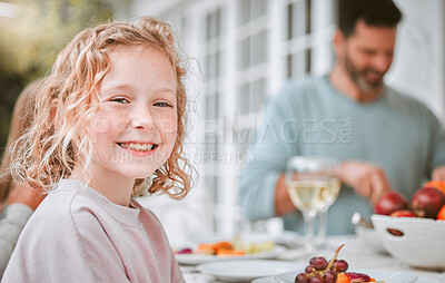 Buy stock photo Shot of a little girl sitting at a tablet with her family at home