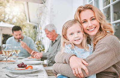 Buy stock photo Shot of a mother hugging her daughter at a family lunch at home