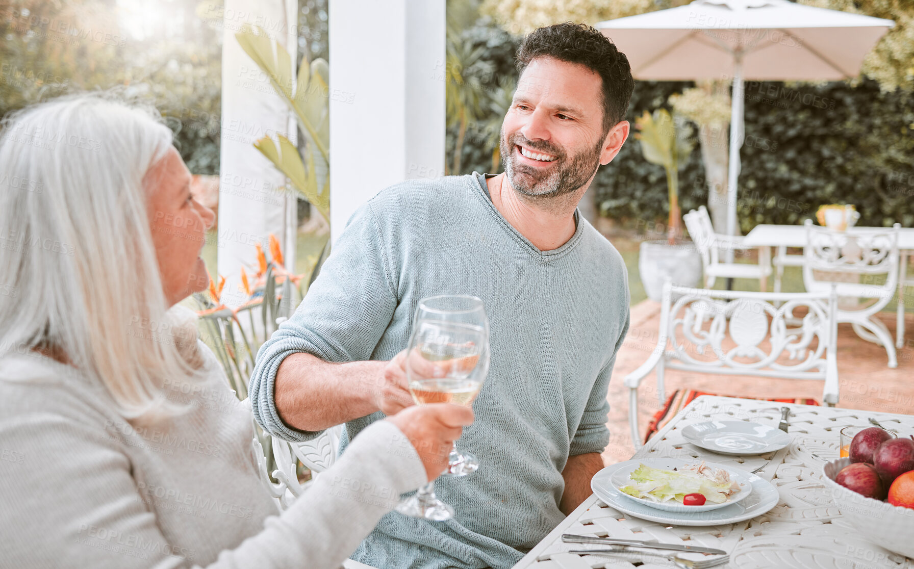 Buy stock photo Shot of a mother and son doing a cheers at lunch outside