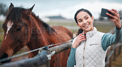 Buy stock photo Shot of an attractive woman taking a selfie while posing with a horse in an enclosed pasture on a farm