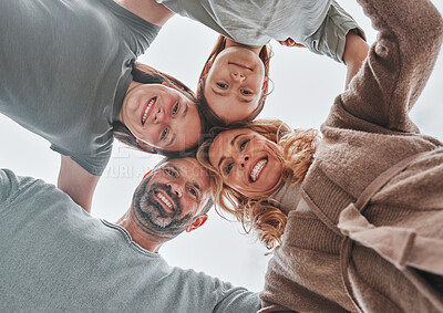 Buy stock photo Shot of a family of four standing together in a huddle