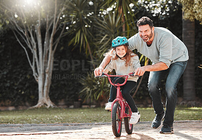 Buy stock photo Shot of a man assisting his daughter while riding a bicycle