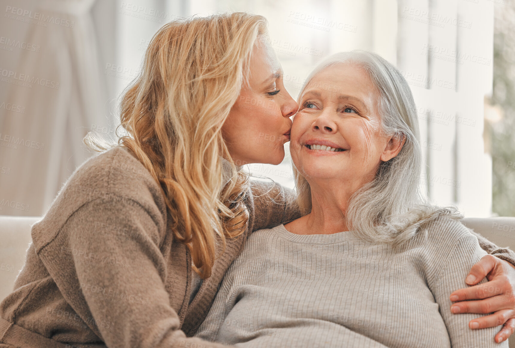 Buy stock photo Hug, kiss or smile with senior mother and daughter on sofa in living room of home together for visit. Support, womens day or wellness with old parent and person embracing in apartment for bonding