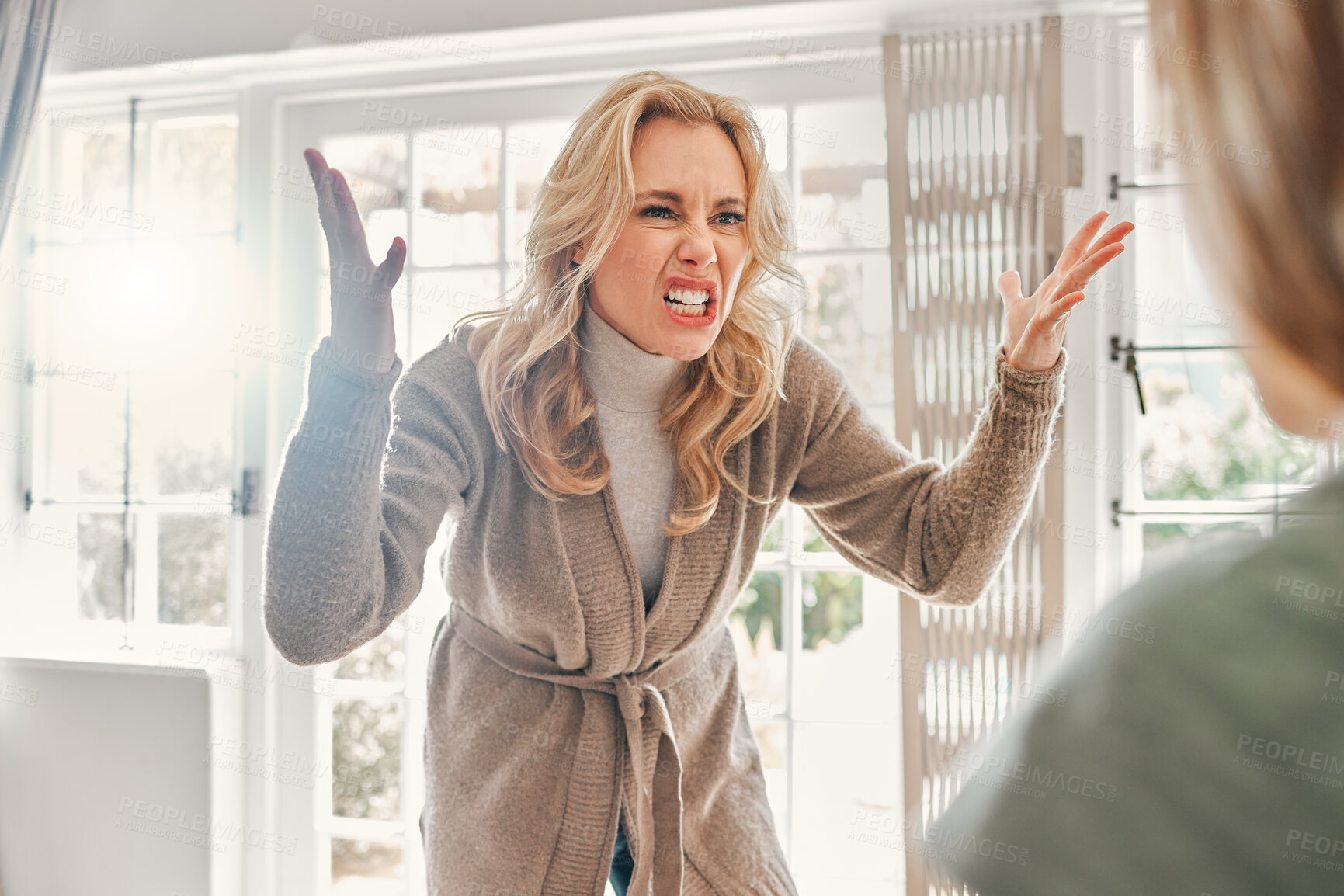 Buy stock photo Shot of a mature woman looking upset while scolding someone at home