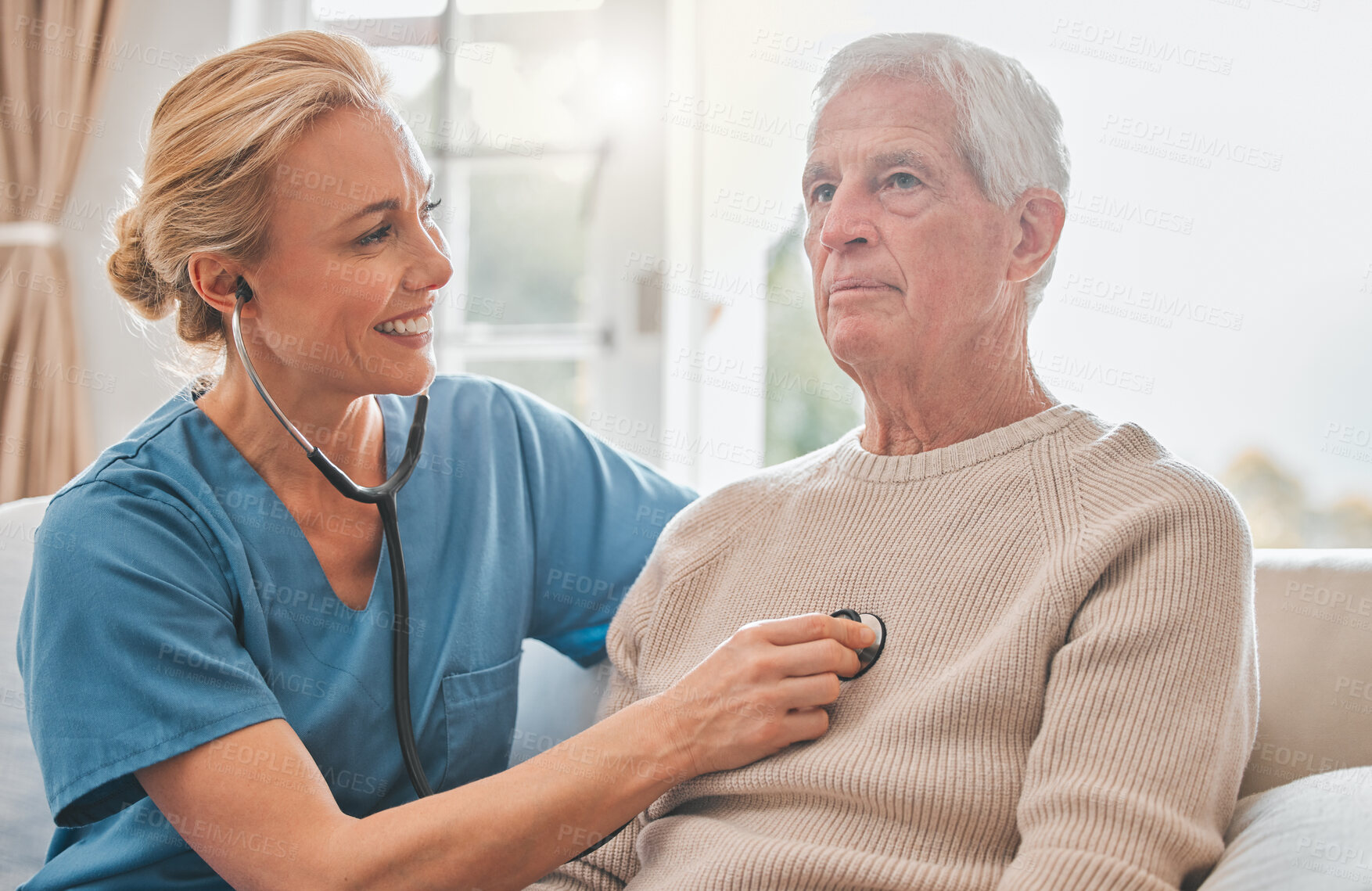 Buy stock photo Shot of a female nurse listening to her patients chest