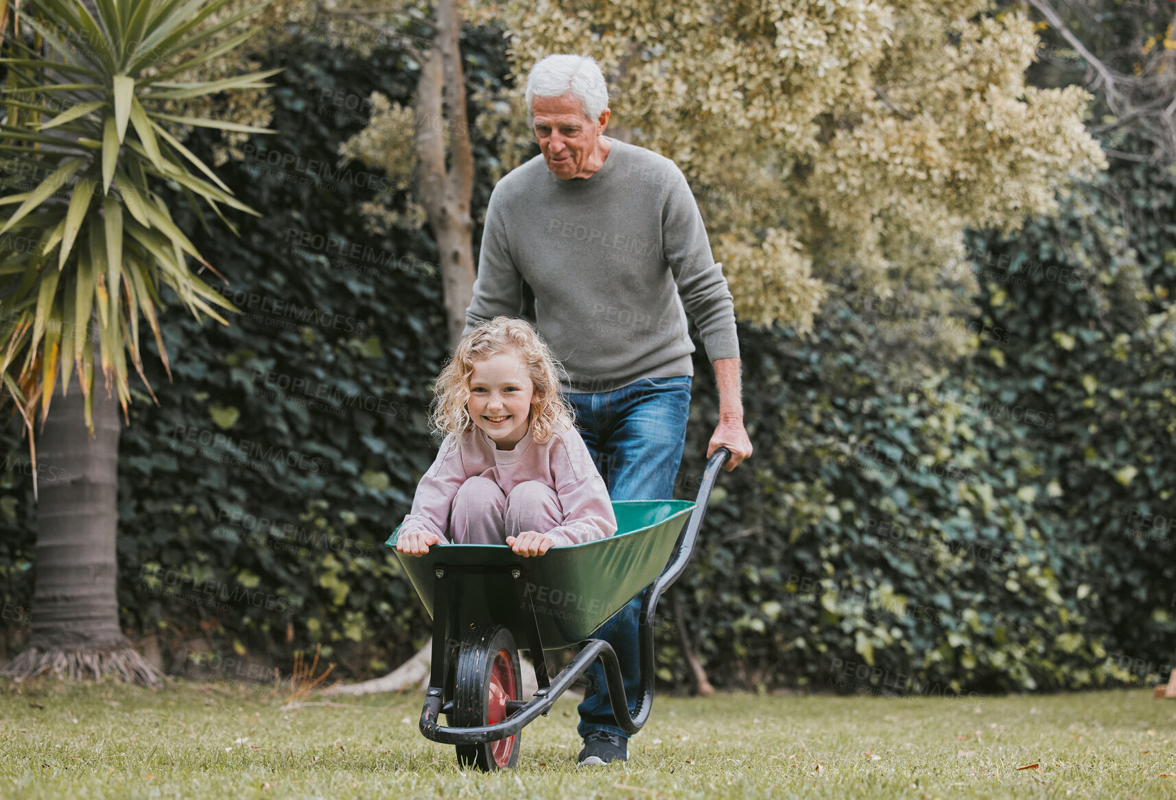 Buy stock photo Shot of an adorable little girl having fun with her grandfather in a garden
