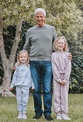Buy stock photo Shot of two adorable little girls standing with their grandfather in a garden