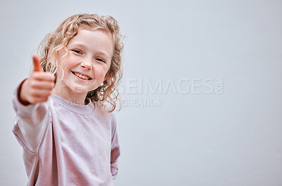 Buy stock photo Studio shot of a little girl showing thumbs up against a grey background
