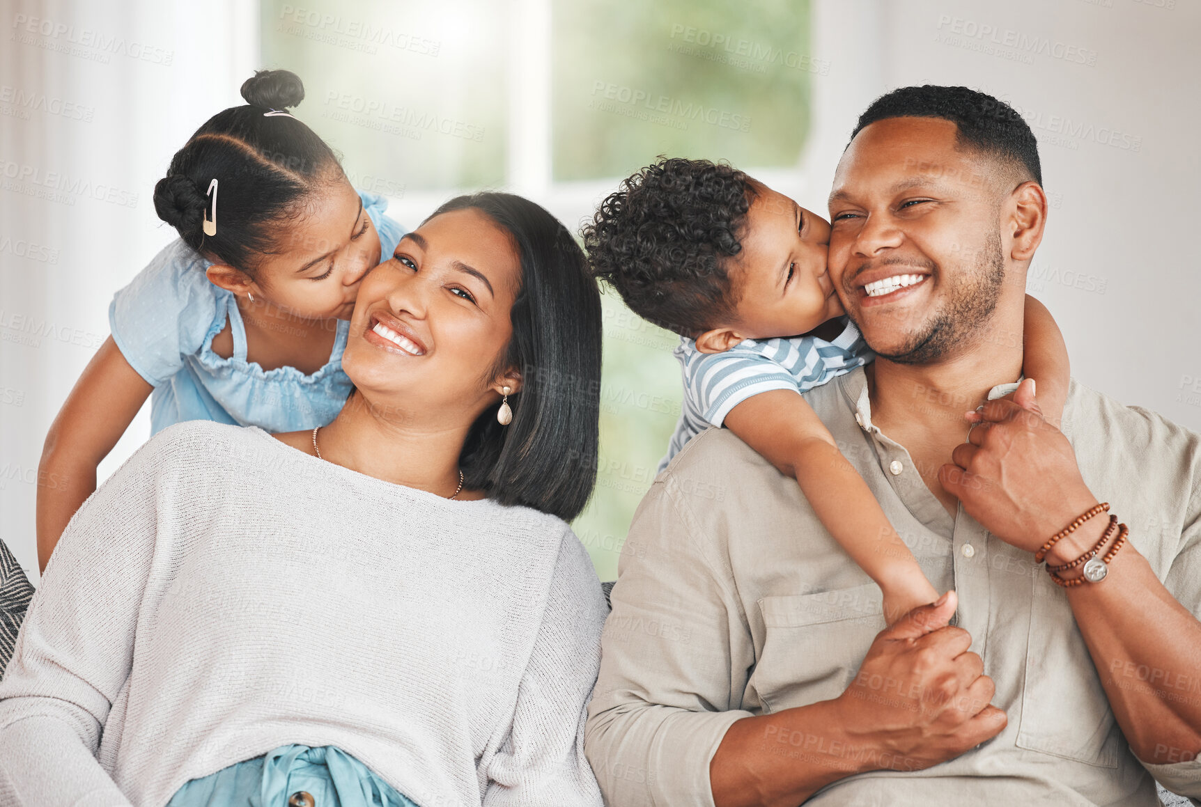 Buy stock photo Mom, dad and hug with children on sofa for bonding with comfort, love and connection for embrace or affection. Mother, father and kids or siblings with kiss on cheek, family home and happy together.