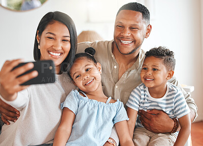 Buy stock photo Shot of a young family taking a selfie while bonding together on a sofa