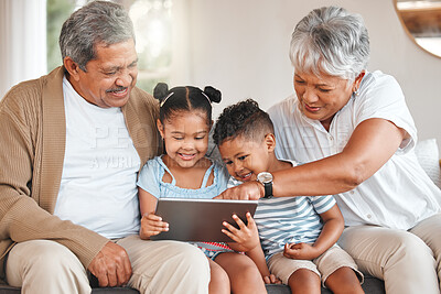 Buy stock photo Shot of grandparents bonding with their grandchildren  and using a digital tablet on a sofa at home