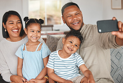 Buy stock photo Shot of a young family taking a selfie while bonding together on a sofa