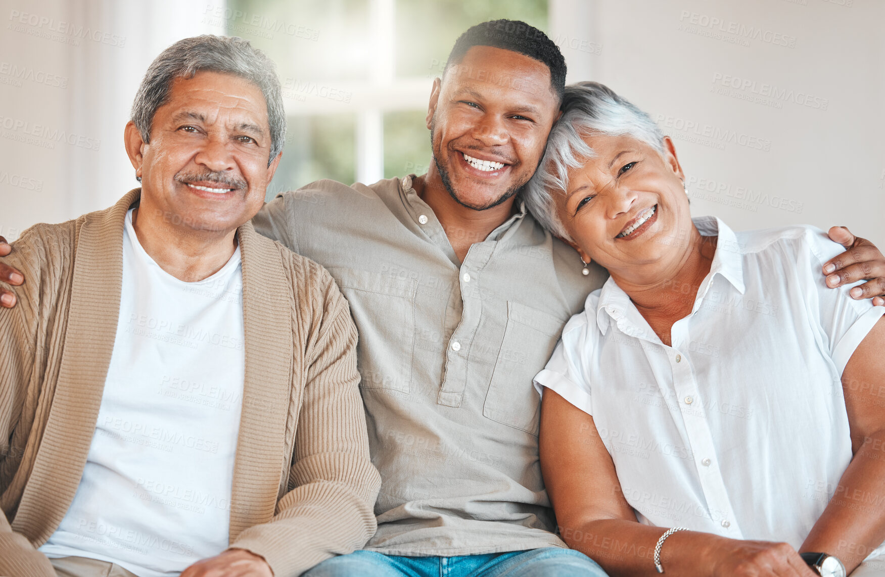 Buy stock photo Portrait of a mature couple bonding on the sofa with their son at home