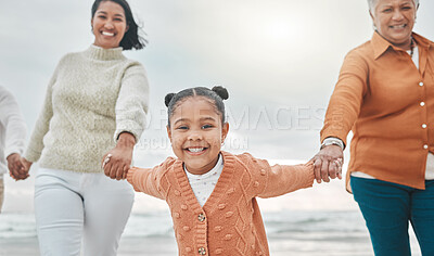 Buy stock photo Cropped shot of an adorable little girl pulling her mother and grandmother along the beach