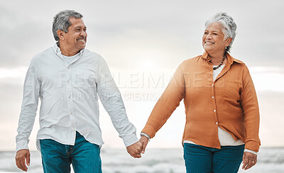 Buy stock photo Senior happy couple, walk beach and holding hands for smile, bond and care with romance, love and vacation. Elderly man, woman and sunset with happiness, retirement and travel by ocean for holiday