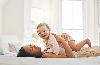 Buy stock photo Mom lying, lift newborn and bed with smile, care and happiness in morning with love, bond or excited face. Young mother, baby and happy in bedroom, family home and holding kid with pride in sunshine