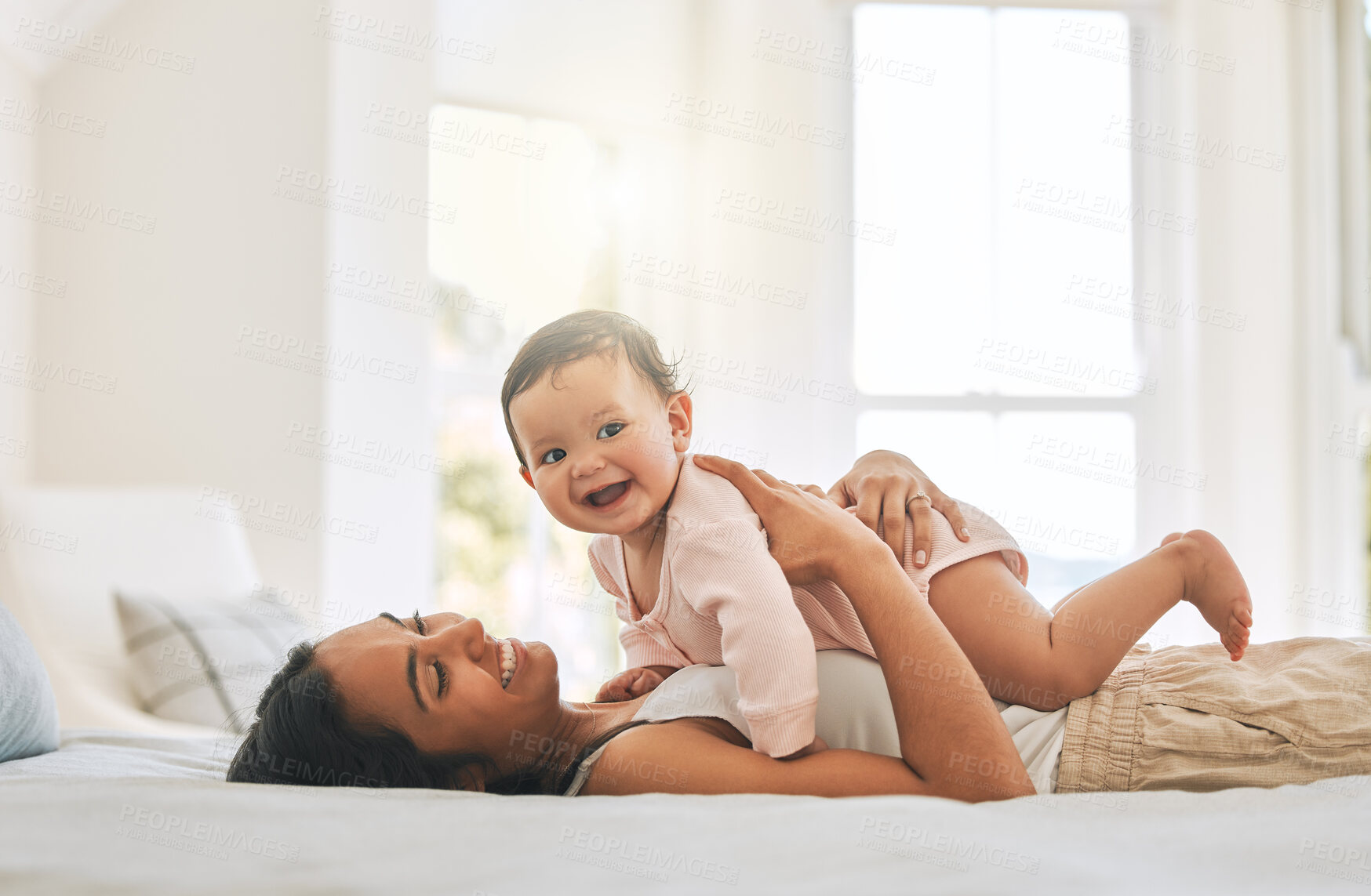 Buy stock photo Mom lying, lift newborn and bed with smile, care and happiness in morning with love, bond or excited face. Young mother, baby and happy in bedroom, family home and holding kid with pride in sunshine