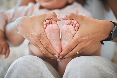 Buy stock photo Baby, feet and hands in heart for love, care and nurture childhood development, growth and wellness of kids. Closeup, mother and hand shape around tiny foot of infant, newborn and child for support