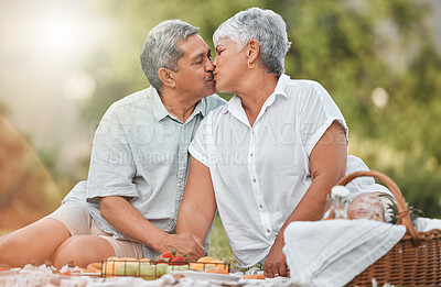 Buy stock photo Shot of a mature couple kissing during a picnic