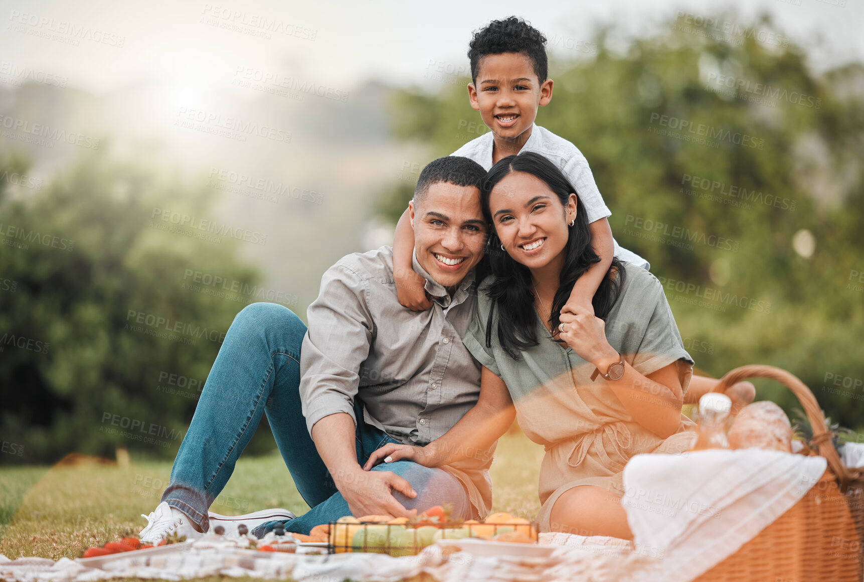 Buy stock photo Portrait, nature and child with parents on picnic for summer on vacation, getaway or weekend trip. Love, fruit and boy kid with mother and father for connection, bonding and hugging in outdoor park.