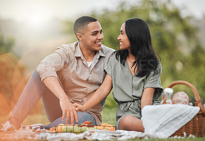 Buy stock photo Shot of a young couple enjoying a picnic together