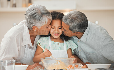 Buy stock photo Shot of two grandparents kissing their grandchild on the cheek while baking