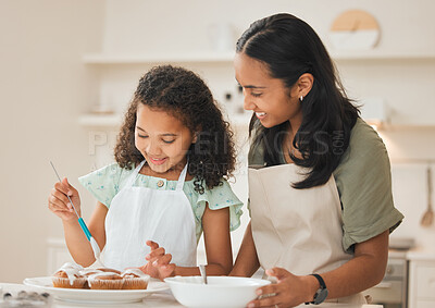 Buy stock photo Shot of a mother and daughter frosting freshly baked cupcakes
