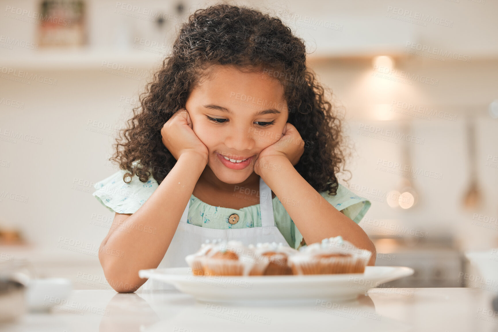 Buy stock photo Shot of a little girl patiently waiting to eat the freshly baked cupcakes