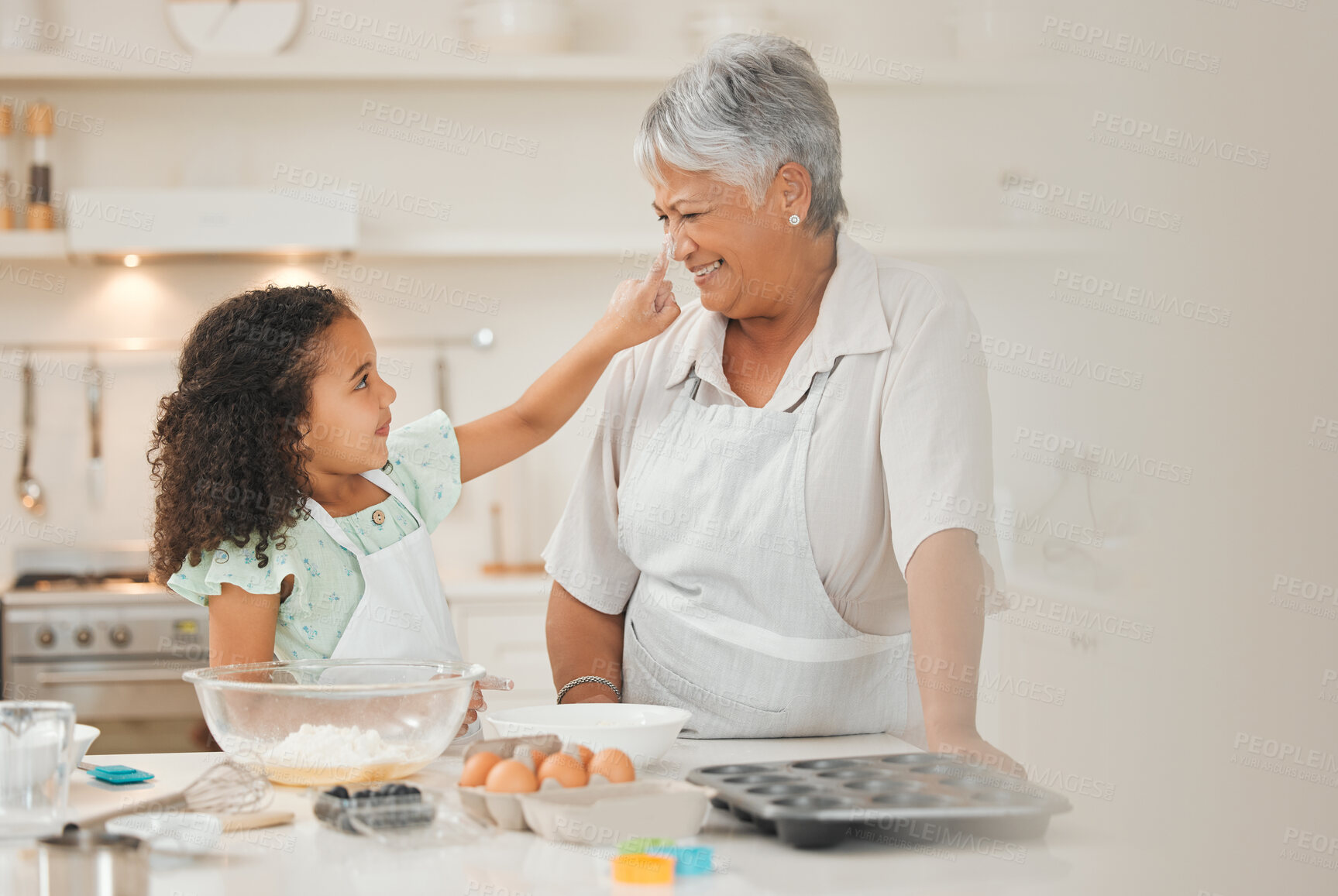 Buy stock photo Baking, playful and child with grandma in kitchen with flour for cake, cupcakes and dessert. Family, home and happy grandmother and girl with ingredients, recipe and food for bonding and learning