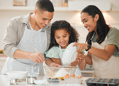 Buy stock photo Shot of a young mother and father baking with their daughter