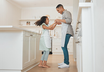 Buy stock photo Shot of a father and daughter dancing in their kitchen while baking
