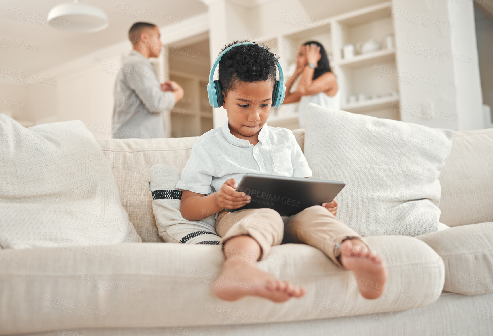 Buy stock photo Boy, headphones and parents fighting in home, tablet and streaming cartoons and online shows for distraction. Mental health, people and marriage conflict with kid on sofa, family break up and house