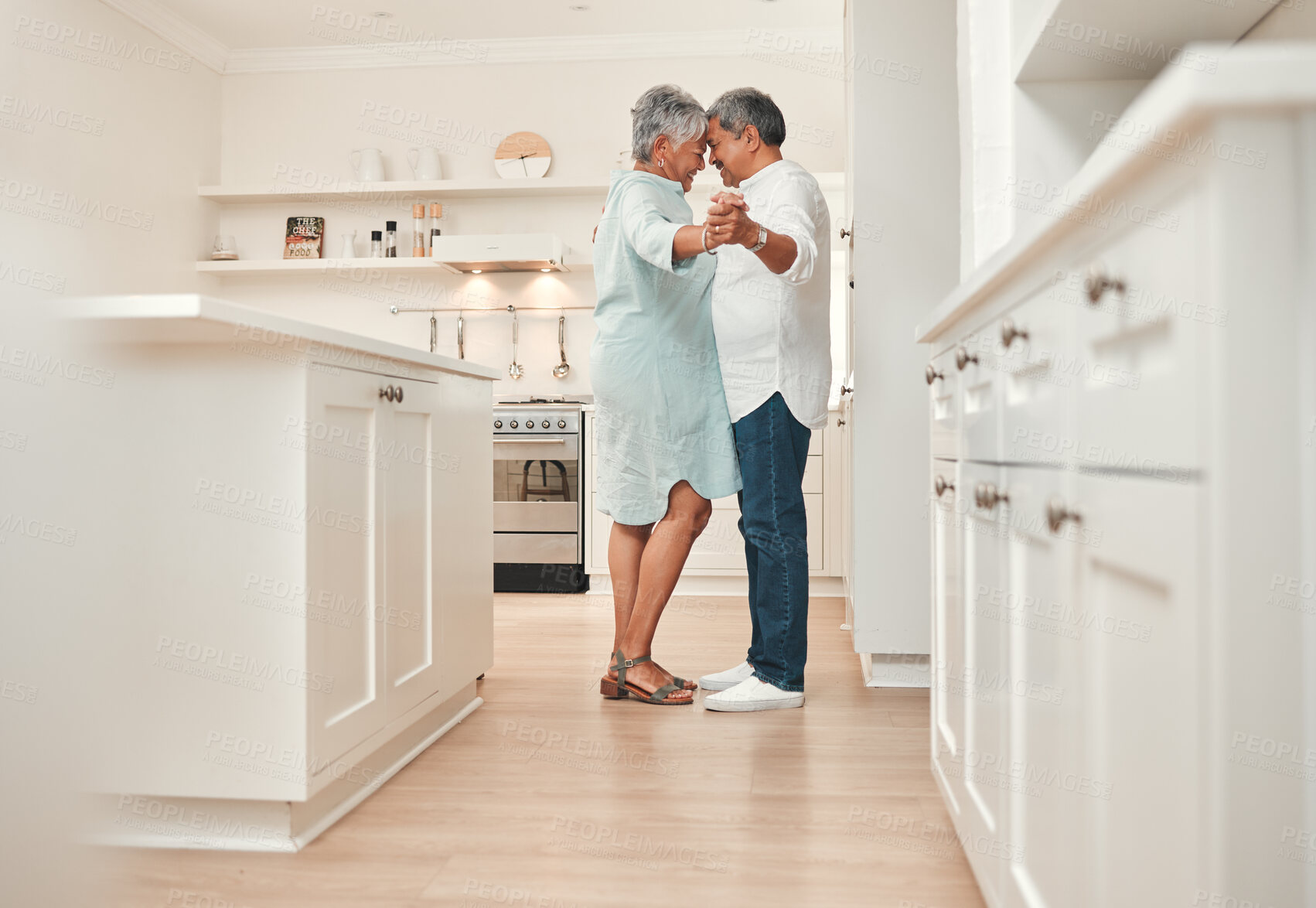 Buy stock photo Dancing, love and senior couple in kitchen, smile and bonding of old man and woman in anniversary. Lounge, sofa and embrace of elderly people with commitment to marriage, care and support in house