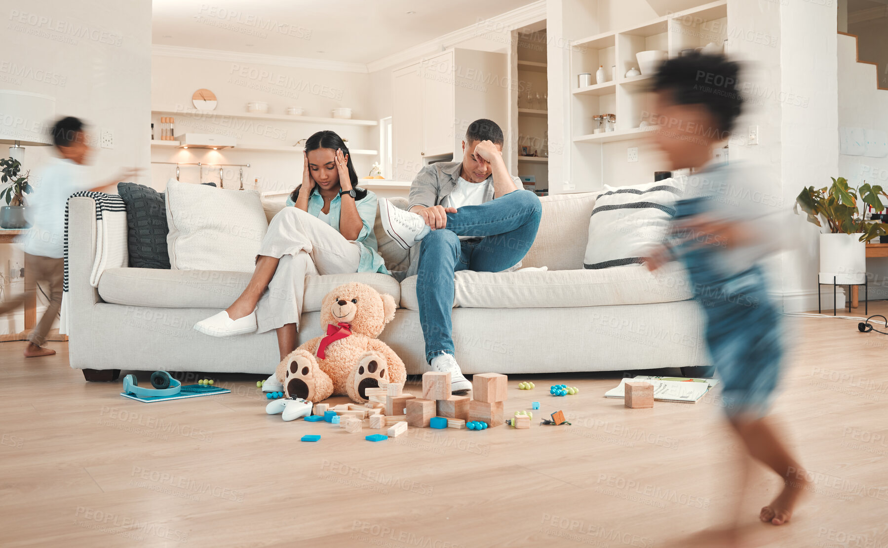 Buy stock photo Parents, children and chaos house or running in living room, ADHD kids and hyper active on weekend break. Frustrated people, sofa and stress for noise and motion blur, movement and energy for burnout