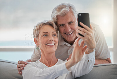 Buy stock photo Cropped shot of an affectionate senior couple taking selfies while relaxing in the living room at home